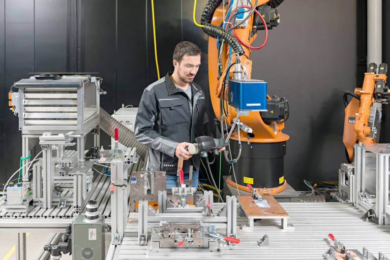 André Heckert, wissenschaftlicher Mitarbeiter am iwb, positioniert den Laser für die Bearbeitung des Metalls für das Fügen von Metall-Kunststoff-Verbindungen.