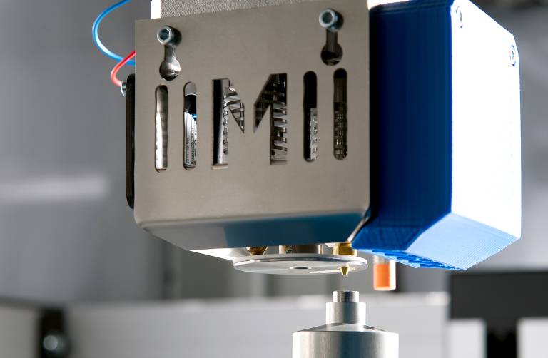 Der Vierfachdruckkopf Multec4Move mit patentiertem Düsenverschluss ist das Herzstück der Maschinen von Multec. Eine integrierte Abstandsmessung (oranger Sensor) ermöglicht eine automatische Bettnivellierung. (Bilder: Brigitte Müller)