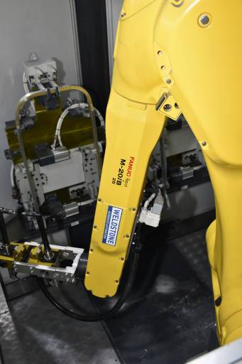 Zentrales Element der Roboterzelle ist ein Fanuc M-20iB/25. Der voll gekapselte Roboter bietet durch sein kompaktes Handgelenk eine sehr gute Zugänglichkeit und weist die ausreichende Steifigkeit auf, um diese Bearbeitungsaufgabe mit hoher Präzision auszuführen.