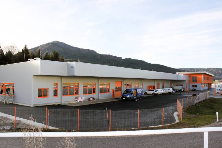 Die neue Fertigungshalle von ABW in Oberwang mit der Kulmspitze im Hintergrund.