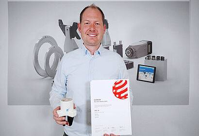 Tobias Hikade (Produktmanager) mit dem RED DOT Zertifikat und dem HRC-07-Greifer. 