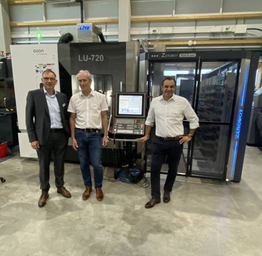 Jürgen Widmann (CEO, EVO), Klaus Hofmann (CEO, Zeroclamp) und Mario Sanna (Vertriebsleitung, Zeroclamp) vor der automatisierten Werkzeugmaschine mit ZEROBOT in der hauseigenen Fertigung.
